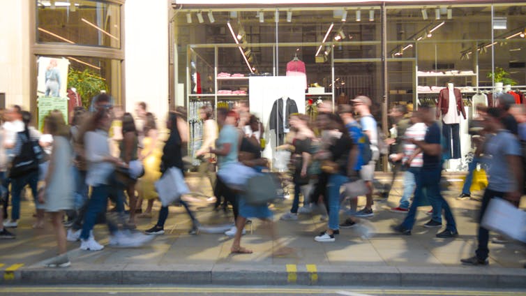 people hurry across a building's entrance