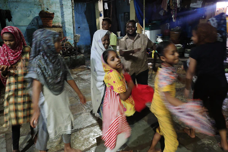 Brightly dressed young people dance in a line formation.