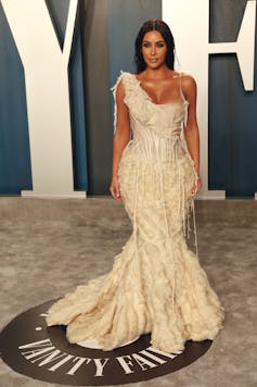 Kim Kardashian wears an Alexander McQueen Oyster dress and a full-length white fishtail gown with distressed details.