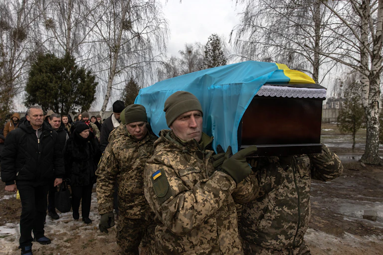 Ukrainian soldiers carry a comrade's coffinat a funeral in Bucha, northwest of Kyiv, Ukraine, 23 December 2022.