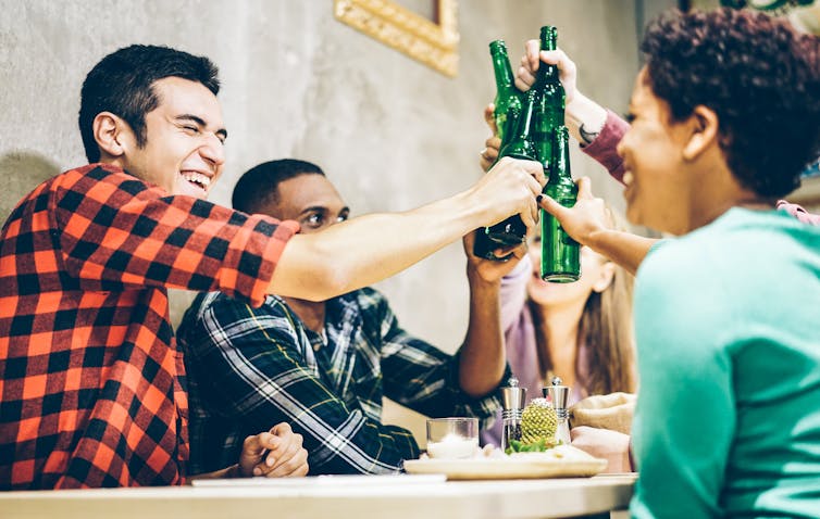 Friends clinking beers at restaurant