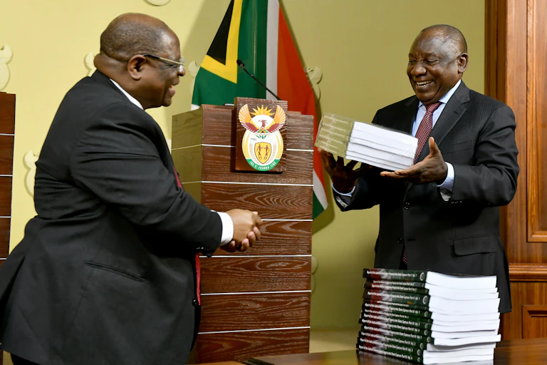 A man receives volumes of reports from another.
