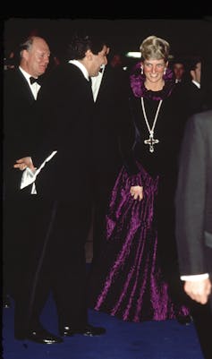 Diana wearing an ataler cloth in a purple velvet high-necked floor-length dress.