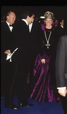 Diana wearing the Attallah Cross with a purple, velvet, high necked, floor length dress.