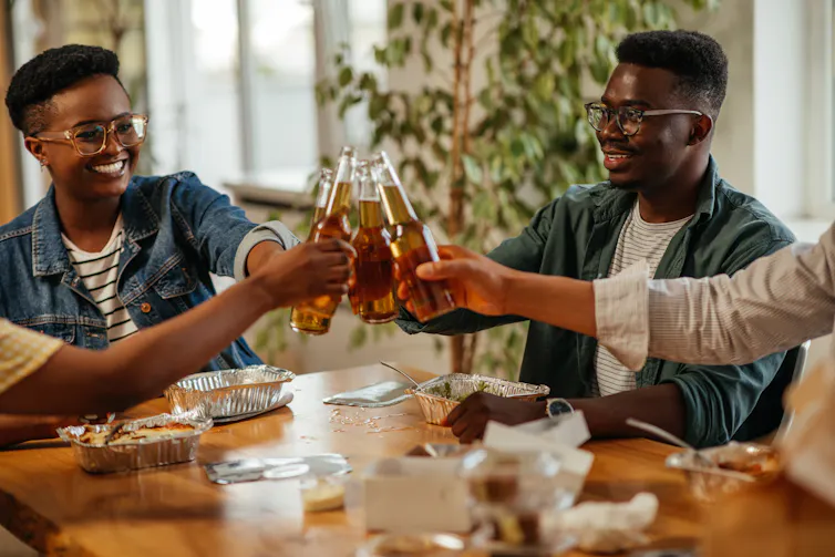 Two friends cheers their craft beers together.