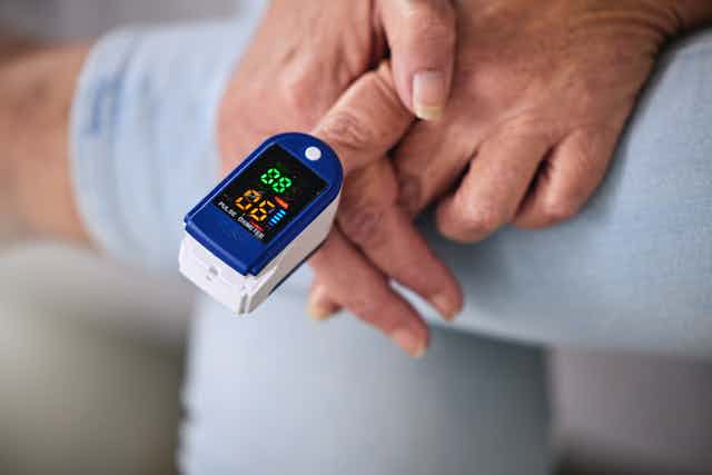 Person with pulse oximeter on their finger