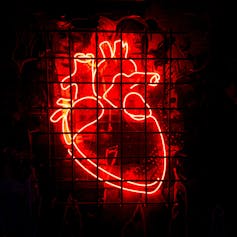 A red neon rendering of an anatomical heart