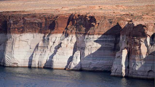 A rock cliff wall, the lower two-thirds white and the upper third red.
