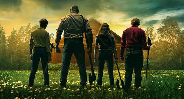 Movie poster showing a family standing in front of a cabin