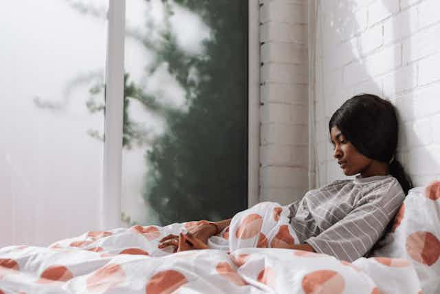 Young girl sitting up in bed