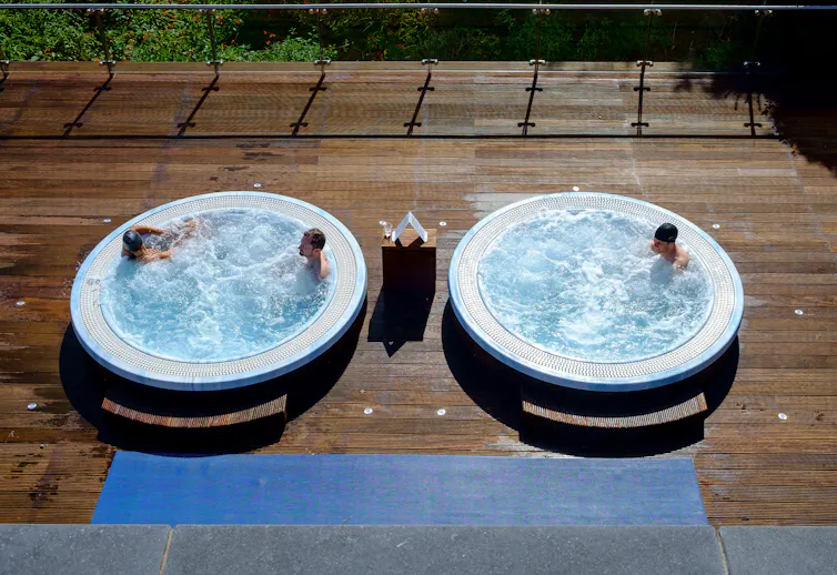 People in hot tubs on the deck.