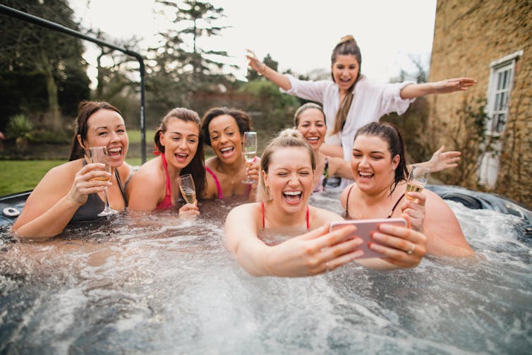 Une femme prend des photos dans un bain à remous