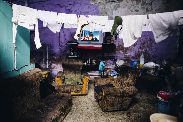 Un tendedero cuelga sobre una suite de tres piezas y frente a un televisor en la vivienda de un _albergue_ de Centro Habana, Cuba, diciembre de 2022.