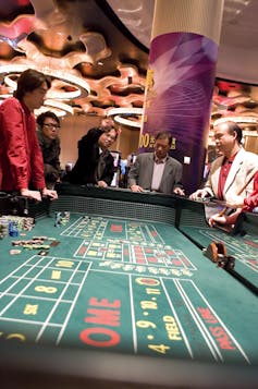 people watch play standing around a casino craps table
