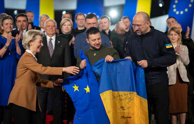 Ursula von der Leyen, Volodymyr Zelensky and Denys Shmyhal hold Ukraine and EU flags at a meeting in Kyiv, Febriary 20223.