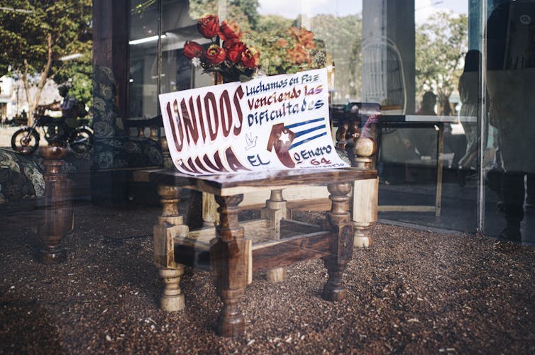 A shop display commemorating the Cuban revolution’s 64th anniversary reads:  ‘United we fight in peace, overcoming all difficulties.’ – Havana, Cuba, December 2022