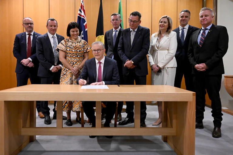PM sits behind desk, premiers stand behind him