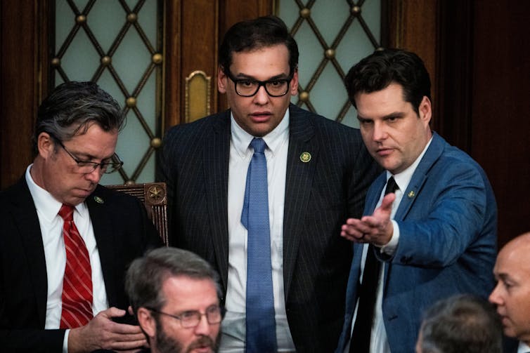 Three men looking towards the camera.