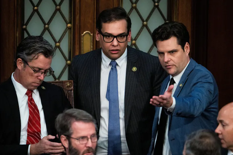 Three men looking towards the camera.