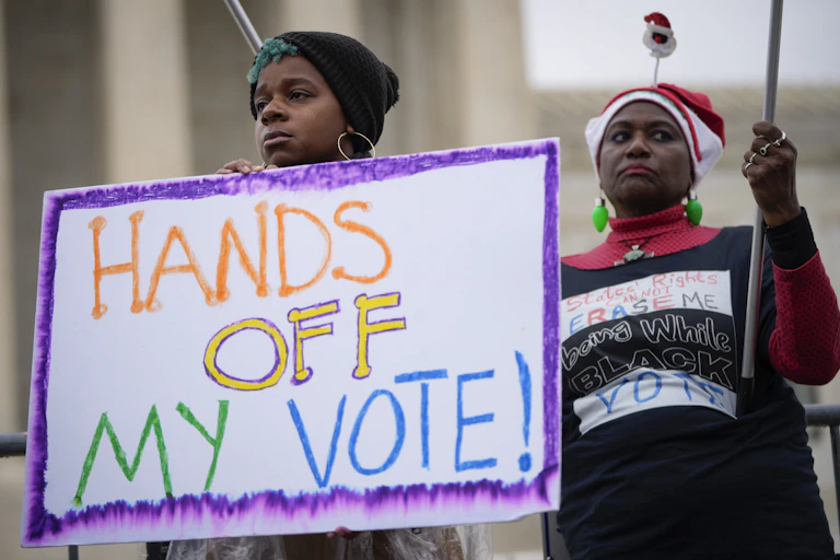 Femmes portant une pancarte « Hands off my vote » devant la Cour suprême des États-Unis
