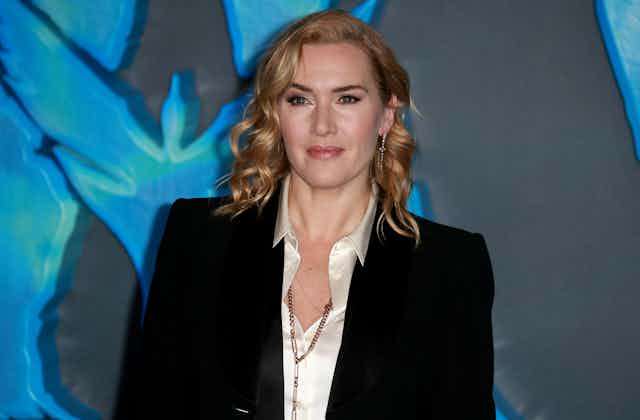 Actor Kate Winslet wearing a black jacket and ivory blouse