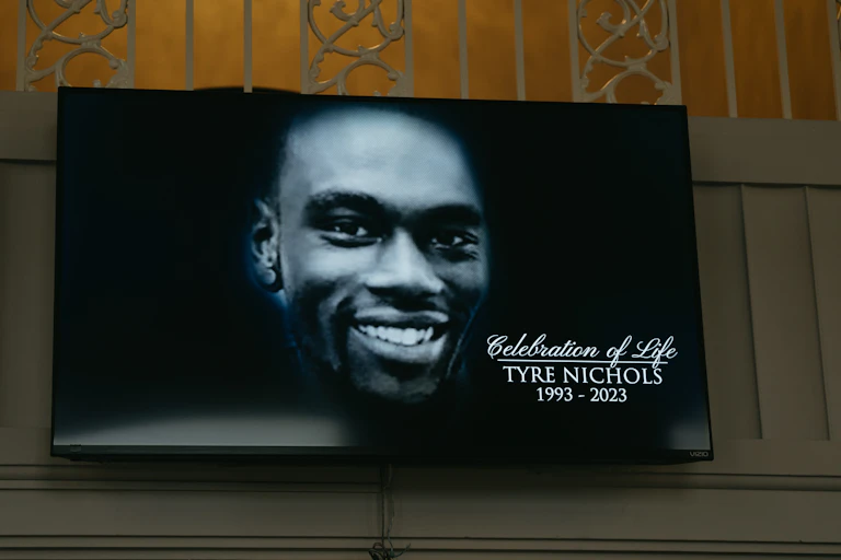 A portrait of a young Black man is seen on the iron gates of the church entrance.