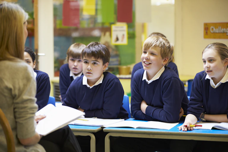 Teacher talking to a row of students.