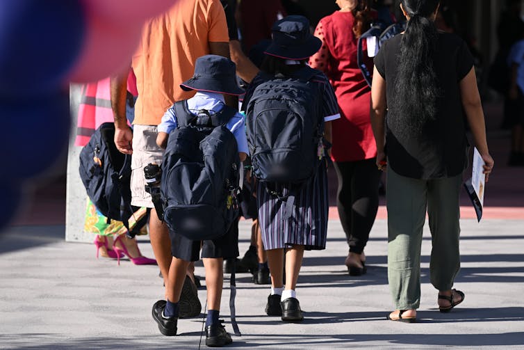 Children walking to school with parents.