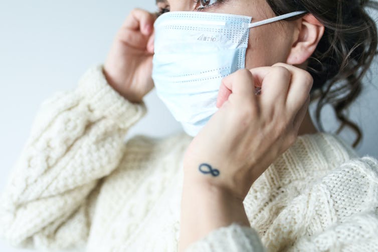 Une femme porte un masque