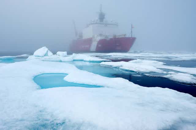 The Coast Guard Cutter Healy surrounded by ice with pools of water on top.