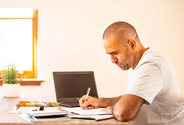 man sits at desk with laptop