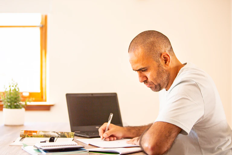 man sits at desk with laptop