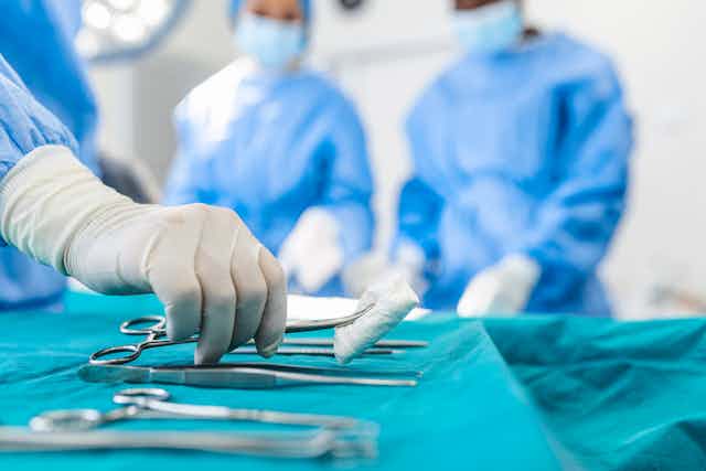 Nurse hand taking surgical instrument