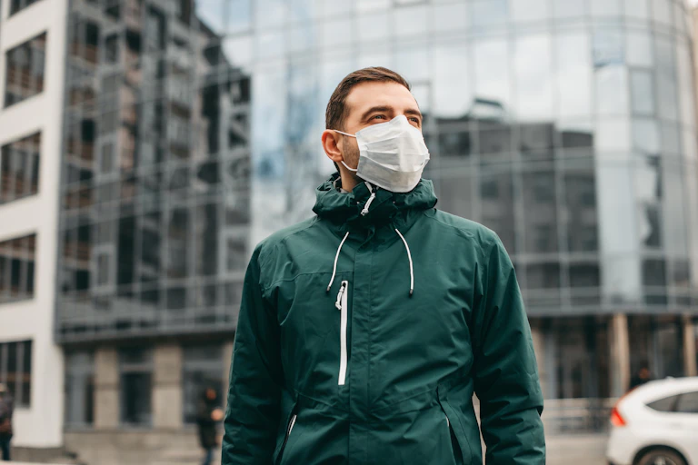 A man wearing a mask outdoors.