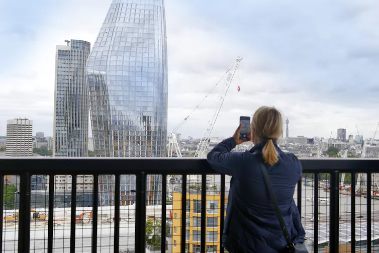 A person on a balcony with a phone.