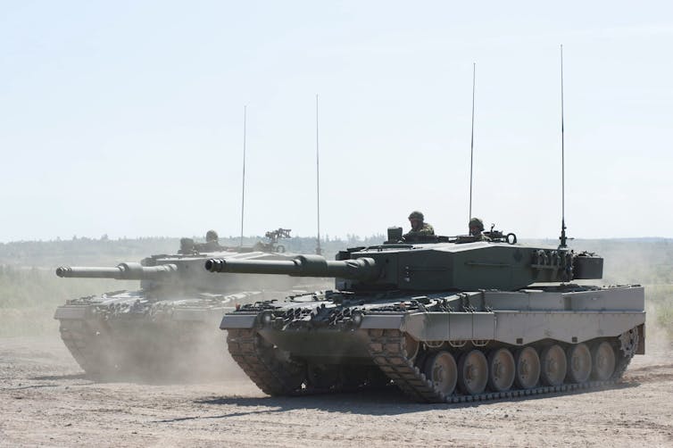 A tank is seen on dusty terrain.