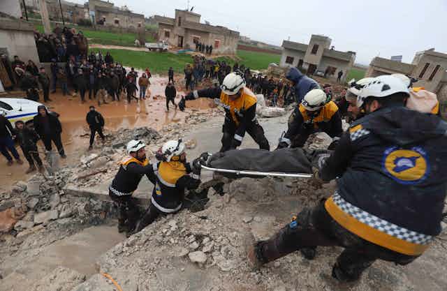 Los equipos de rescate sacan una camilla de los escombros