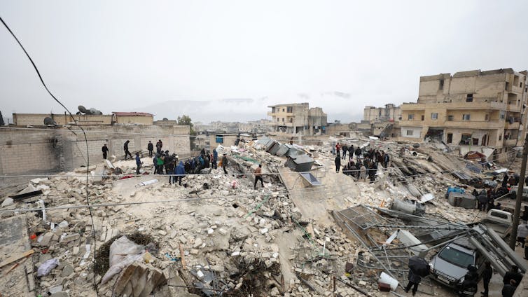 People stand on rubble