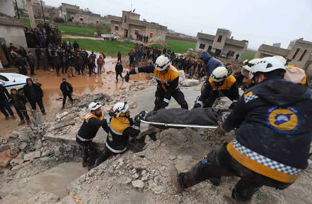 Rescue workers pull a stretcher from the rubble