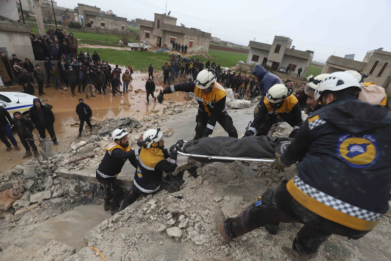 Rescue workers pull a stretcher from the rubble