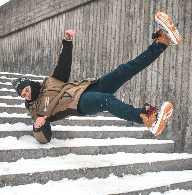 A man slips down a snowy staircase