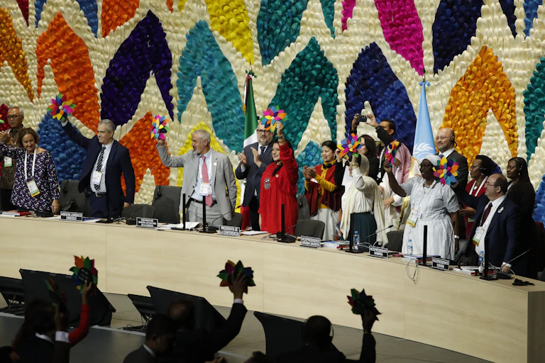 Diplomats hold up cardboard flowers.