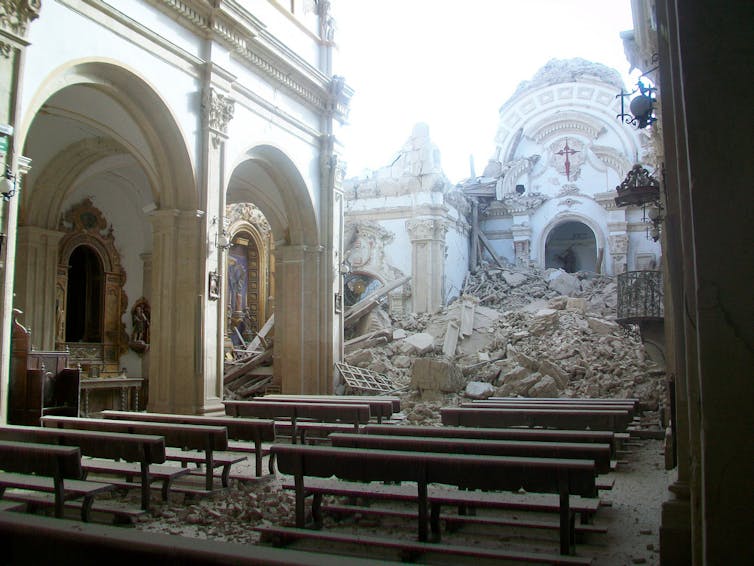 Interior de iglesia con el techo derruido.