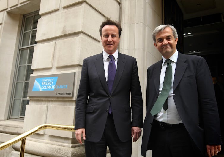 David Cameron e Chris Huhne sorrindo do lado de fora do prédio do DECC.