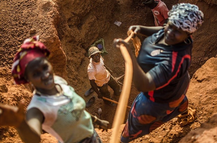 Uma foto olhando para um homem no fundo de uma mina de ouro.