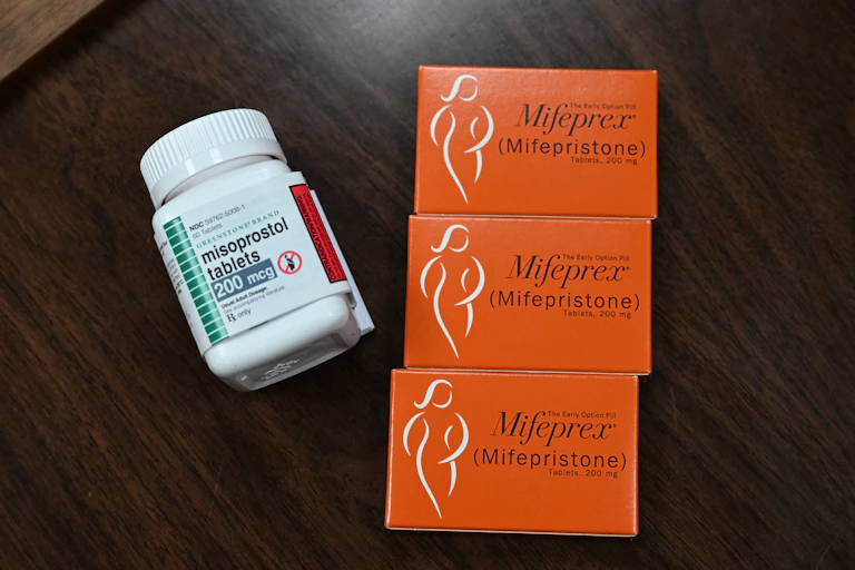 A bottle of pills and three boxes of another kind of medication