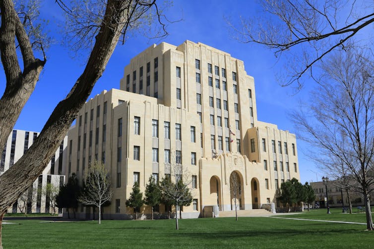 Large beige building with a bright green lawn