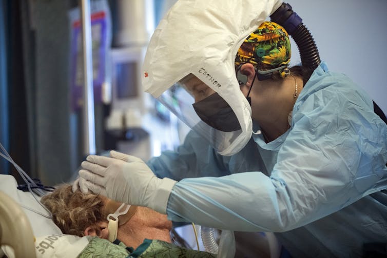 ICU clinician checks on a COVID patient