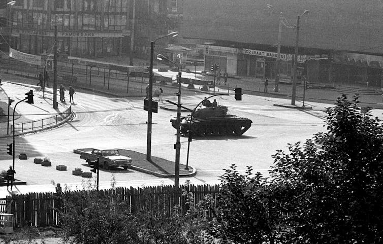 A tank is seen in the middle of a city square.