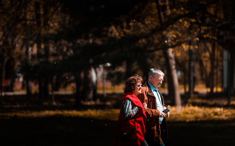 Older couple walk in a forest